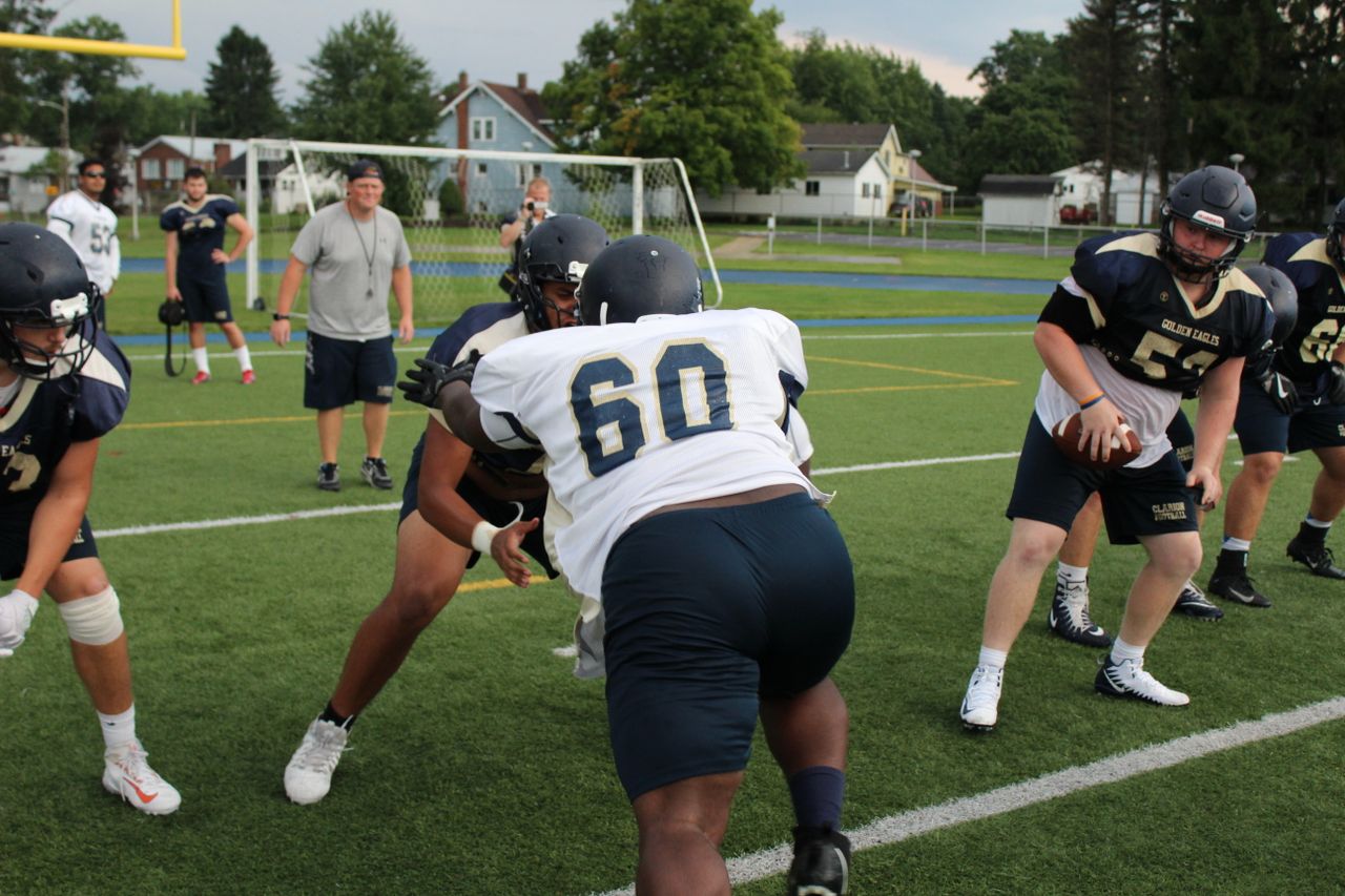 gallery-1 Dynamic scene of American football players in action during practice. Focus on teamwork and strategy.